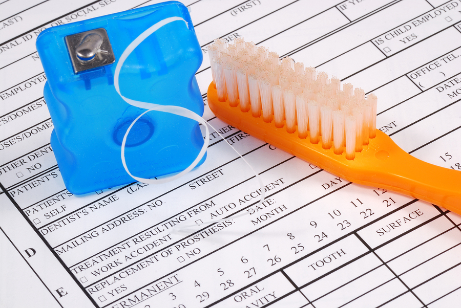 Dental claim form with toothbrush concepts of the rising cost of dental care