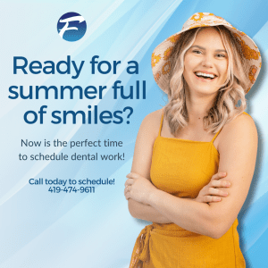 Smiling woman wearing a yellow sundress and hat. Blue background.